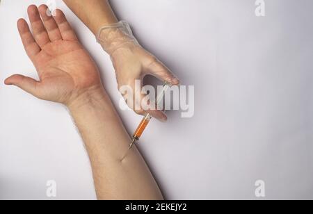Le médecin fait une injection dans la main d'un personne Banque D'Images