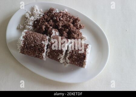 Gâteau de millet à la vapeur. Fait avec de la farine de millet combinée avec du cocon râpé et cuit à la vapeur dans un récipient spécial. Il est également appelé Ragi putt Banque D'Images