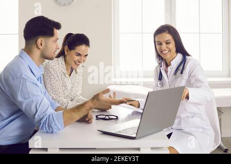 Couple heureux regardant l'image de bébé à ultrasons sur l'écran de ordinateur portable au bureau du médecin Banque D'Images