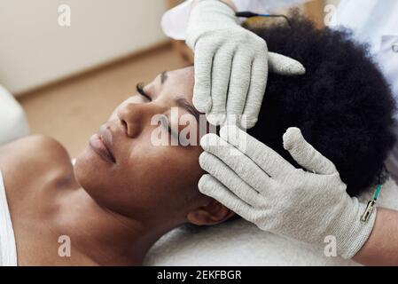 Rajeunissement du visage avec l'aide de la thérapie de microcourant. Massage du drainage lymphatique. Micro-sensoriel électrique BIO EMS traitement microcurrent pour le visage Banque D'Images