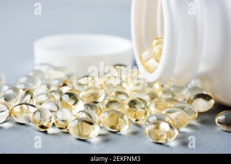 Capsules jaunes de vitamine D sur une surface grise. Banque D'Images