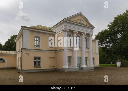 Devant le manoir de Kumna. Petit bâtiment médiéval rénové dans le style néo-classique. Murs jaune clair, colonnes blanches de type grec, fenêtres voûtées. Banque D'Images