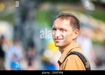 Gros plan portrait de jeune homme heureux touriste personnes souriant Avec arrière-plan bokeh du parc de la ville en Ukraine Banque D'Images