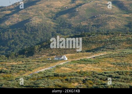 Maison blanche au milieu d'un paysage de montagne vert lors d'une journée d'été à Fafe, Portugal Banque D'Images
