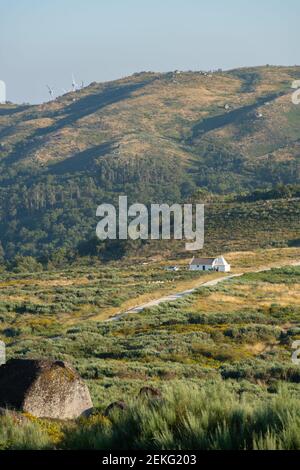 Maison blanche au milieu d'un paysage de montagne vert lors d'une journée d'été à Fafe, Portugal Banque D'Images