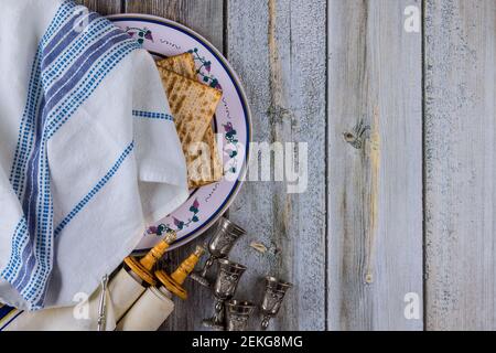 Fête de la famille juive la Pâque célébrant les symboles de la grande matzah kasher traditionnelle, de la séder, des manuscrits de torah et de quatre tasses de vin Banque D'Images