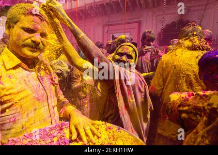 Femme âgée jetant de la poudre colorée à la veuve Holi tenu au temple de Gopinath. À cette célébration Holi, les veuves commencent par jeter des pétales de fleurs, et Banque D'Images