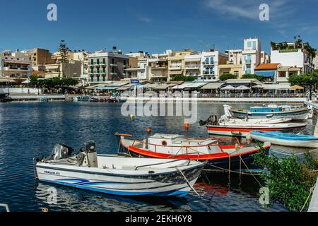 Agios Nikolaos, Crète - octobre 6,2019. Vue sur le petit lac lagon de Voulismeni et le port avec des bateaux entourés de plusieurs bars et restaurants. Banque D'Images