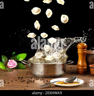 beaucoup de délicieux boulettes tombent dans une casserole d'eau Banque D'Images