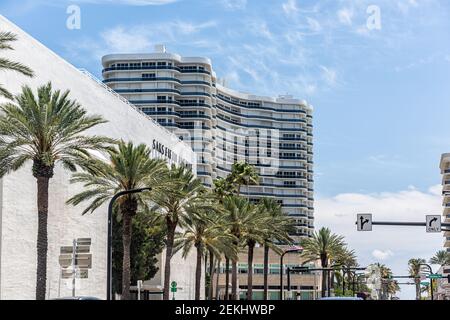 Bal Harbour, États-Unis - 8 mai 2018 : Bay Harbour à Miami en Floride avec des palmiers près d'un immeuble d'appartements en copropriété, Saks Fifth Avenue grand magasin en s. Banque D'Images