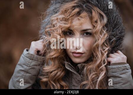 Portrait d'une jeune femme avec des cheveux bouclés en veste d'hiver. Copier l'espace Banque D'Images