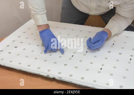 Panneau démonté du grand téléviseur LCD dans le centre de service. Le technicien retire l'éclairage LED pour réparation. Débogage Banque D'Images
