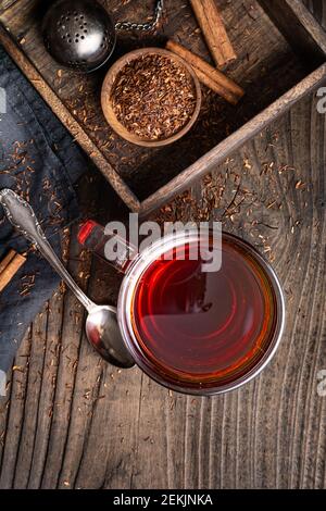 Thé Rooibos fraîchement préparé rempli d'antioxydants sur fond de bois Banque D'Images