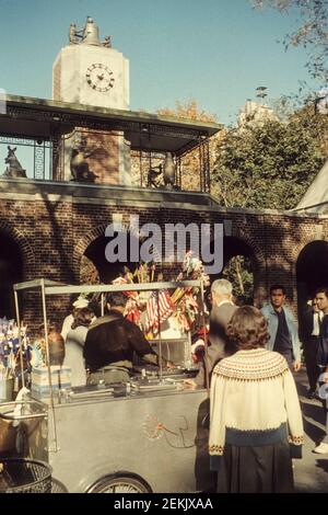 Stand de rafraîchissement qui vend également des drapeaux devant la tour de l'horloge à l'entrée nord du Central Park. New York City, NYC, États-Unis, 1965 Banque D'Images