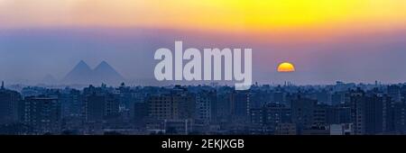 Paysage urbain brumeux du Caire avec les pyramides de Gizeh au coucher du soleil, le Caire, Egypte Banque D'Images