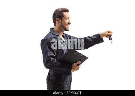 Mécanicien dans des combinaisons tenant une planchette à pince et les clés de voiture isolées sur fond blanc Banque D'Images