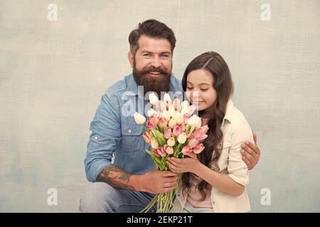 Elle vaut tous les trésors. Tulipes tendre pour fille. Bouquet de tulipes d'homme. Père donnant des tulipes fille. Père avec fleurs. Fête d'anniversaire. Journée internationale de la femme. Fleuriste. Tradition familiale. Banque D'Images