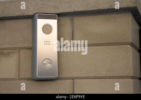 Panneau intercom argent avec caméra vidéo sur une brique beige pilier de clôture d'une maison privée Banque D'Images