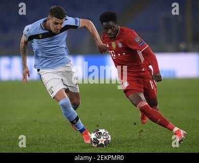 Rome, Italie. 23 février 2021. Alphonso Davies (R) du Bayern de Munich rivalise avec Sergej Milinkovic-Savic du Latium lors d'un tour de la Ligue des champions de l'UEFA de 16 match de football de première jambe entre le Latium et le Bayern de Munich à Rome, Italie, le 23 février 2021. Credit: Augusto Casasoli/Xinhua/Alamy Live News Banque D'Images