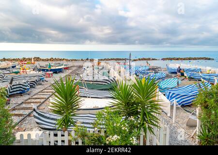 Le matin, vue sur une marina en bateau colorée sur la plage de galets de Ventimiglia, en Italie, le long de la Riviera italienne. Banque D'Images