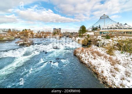 La rivière Spokane passe devant le pavillon d'exposition et le parc Riverfront au centre-ville de Spokane, Washington, États-Unis, en hiver, avec de la neige au sol. Banque D'Images