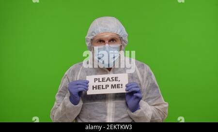 Médecin travailleur médecin médecin en costume PPE avec texte inscription slogan sur papier - s'il vous plaît, aide Me. isolé sur chroma fond clé en attente de vaccination injection contre le coronavirus covid-19 pandémie Banque D'Images