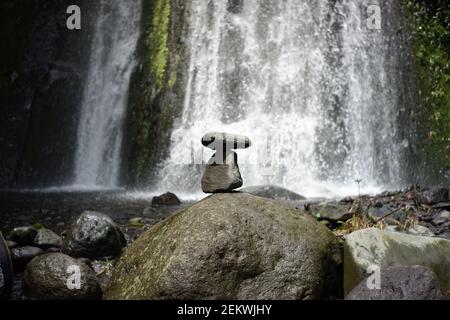 jouez à l'équilibre des rochers dans le flux d'eau de la rivière. détente dans la nature tropicale fraîche. équilibre des roches avec fond de cascade Banque D'Images