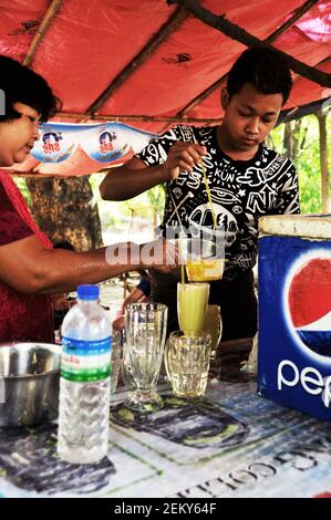 Les vendeurs birmans utilisent des outils et de l'équipement de cuisine et de fabrication sucre de canne frais jus de birmanie style pour les voyageurs de vente Au marché local près de Manda Banque D'Images