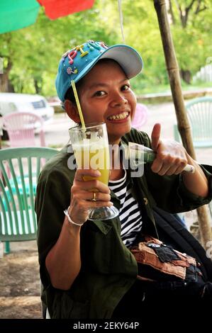 Voyageurs femmes thaïlandaises achètent et boivent de la canne à sucre fraîche jus de fruit de style birman pour les voyageurs en vente sur le marché local près du palais Mandalay le 2 juin 2015 Banque D'Images