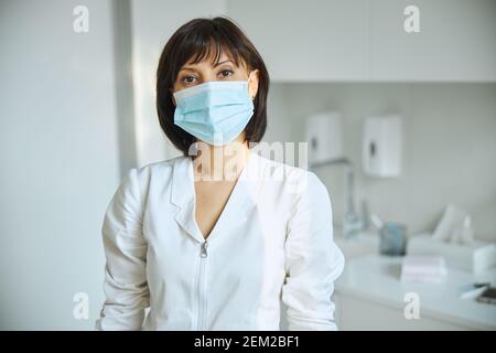 Médecin expérimenté dans un visage couvrant regardant la caméra Banque D'Images