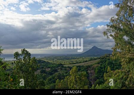 Vue sur la plaine côtière du côté est de l'île Maurice avec nuages de l'après-midi et pluie s'amassent sur la végétation luxuriante. Banque D'Images