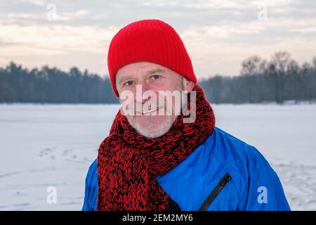 Homme âgé debout dans la forêt d'hiver, se reposant après l'exercice Banque D'Images