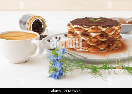 Tiramisu maison ronde, sans cuisson dessert sucré traditionnel italien. Tableau bleu avec du gâteau, bol avec la poudre de cacao, biscuits éponge ronde, les grains de café Banque D'Images