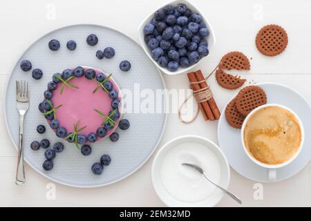 Les deux couleurs mini bleuets gâteau au fromage. Sans cuisson ronde cheesecake, partie découpée sur la petite plaque avec quelques cookies dans le focus. Haut de gâteau décorer Banque D'Images