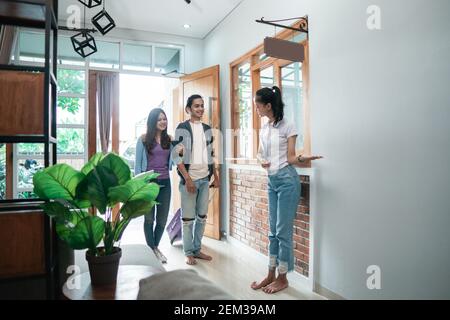 portrait du personnel de la maison d'hôtes asiatique accueillant un couple dans un hôtel boutique Banque D'Images