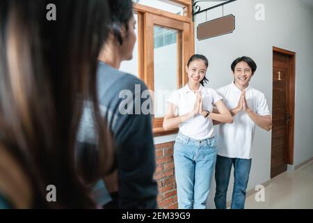 portrait du personnel de la maison d'hôtes asiatique accueillant un couple dans un hôtel boutique Banque D'Images