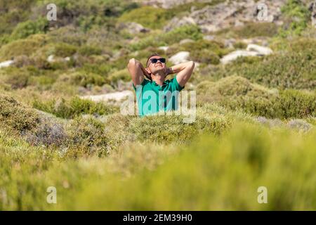 Un homme heureux dans un champ vert dans une chemise. Banque D'Images