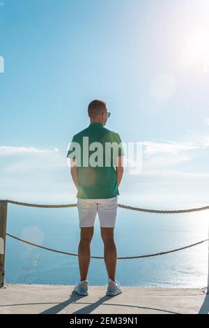 Un homme heureux dans une chemise verte sur fond de mer. Banque D'Images