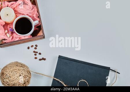 Livre avec bougie bleue et panier de tasse de café sur fond blanc Banque D'Images