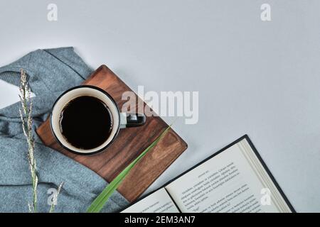 Une tasse de café avec livre et branche sur le planche en bois Banque D'Images