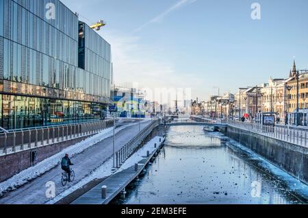 Delft, pays-Bas, 13 février 2021 : vue sur le canal Westsingelgracht recouvert de glace avec à gauche la façade de la nouvelle gare Banque D'Images