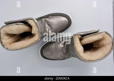 Bottes d'hiver imperméables pour femmes. Bottes chaudes en bronze argenté avec mastic chaud. Chaussures de sport chaudes sur une plate-forme blanche très épaisse. Banque D'Images