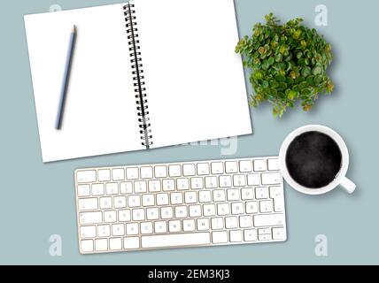 vue de dessus gabarit de bureau avec clavier d'ordinateur, bloc-notes en spirale avec espace pour copier, crayon, tasse à café et plante en pot Banque D'Images