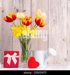Fleur de tulipe dans vase en verre sur table en bois fond de mur pour le concept de la fête des mères. Banque D'Images