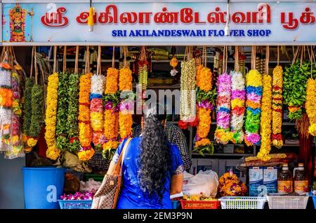 Singapour, Singapour - 5 décembre 2015. Une femme se tient dans un petit fleuriste de Little India, qui vend des guirlandes florales fraîches utilisées dans l'hindouisme. Banque D'Images