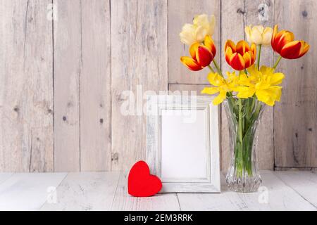 Fleur de tulipe dans vase en verre sur table en bois fond de mur pour le concept de la fête des mères. Banque D'Images