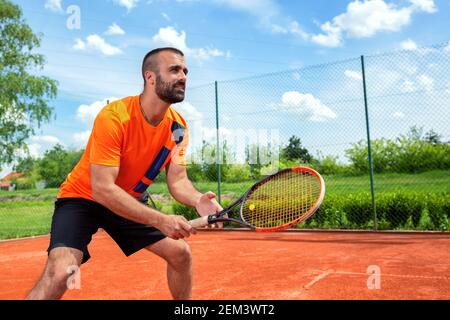 Barbu gars se préparant à recevoir un service de tennis, entraînement dur concept Banque D'Images