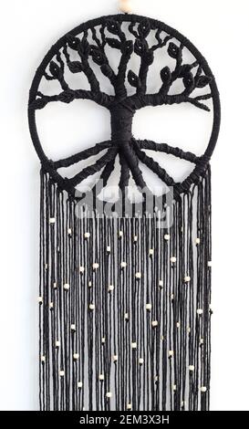 Arbre de vie en macrame noir tissé à la main fait de blanc perles accrochées au mur Banque D'Images