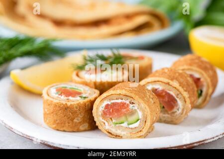 Rouleaux de crêpe avec saumon, concombre, aneth et fromage à la crème. Amuse-gueule Banque D'Images