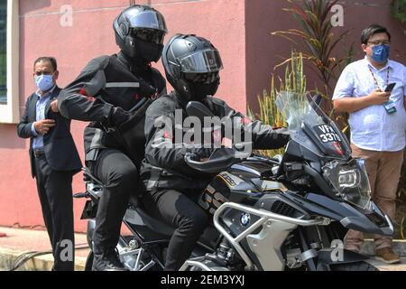 Putrajaya, Malaisie. 20 février 2021. Les agents de sécurité sur une moto BMW attendent devant le bureau du district sanitaire de Putrajaya alors que le Premier ministre reçoit la première dose de vaccin Pfizer-BioNTech COVID-19 à Putrajaya.Malaysia lancera le plus grand programme de vaccination jamais réalisé dans le pays. 532 centres de vaccination à l'échelle nationale sont sur le point de lancer le Programme national d'immunisation COVID-19 à compter du 24 février 2021. La première phase comprendra 500,000 membres du personnel médical et non médical. Crédit : Calvin Pan/SOPA Images/ZUMA Wire/Alay Live News Banque D'Images